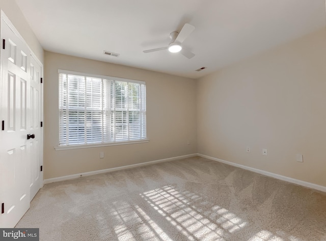 unfurnished room featuring ceiling fan and light colored carpet