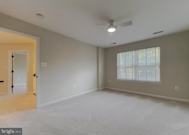 empty room with ceiling fan and light colored carpet