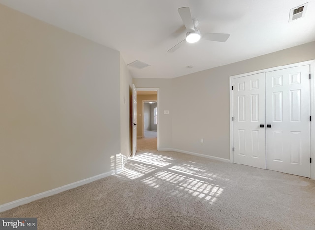 unfurnished bedroom with light colored carpet, a closet, and ceiling fan