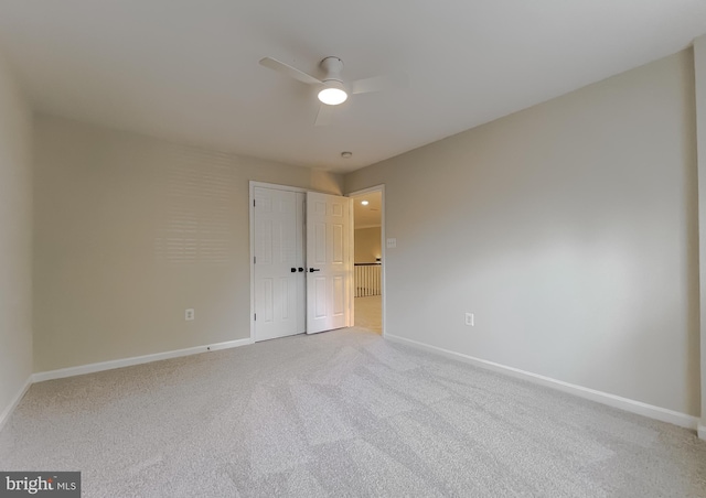 carpeted spare room featuring ceiling fan