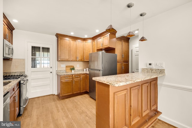 kitchen with kitchen peninsula, backsplash, appliances with stainless steel finishes, light hardwood / wood-style flooring, and pendant lighting