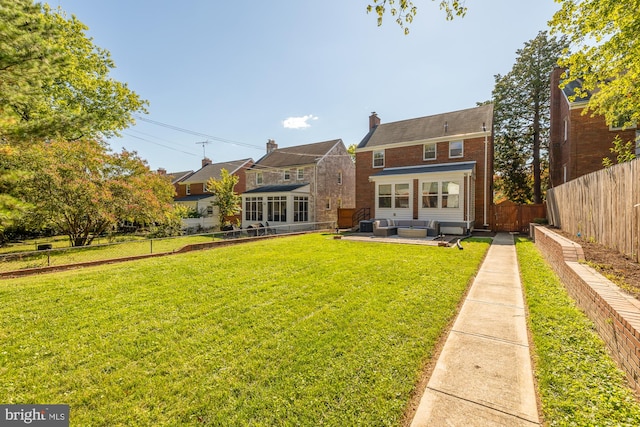 back of property with a yard and a patio