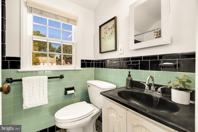 bathroom featuring vanity, toilet, tile walls, and vaulted ceiling