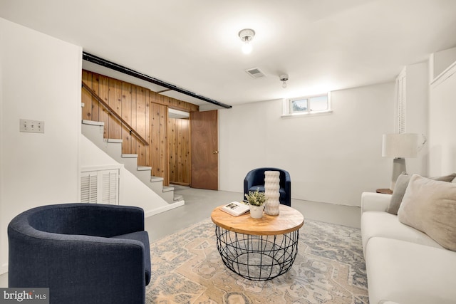 living room with concrete floors and wooden walls