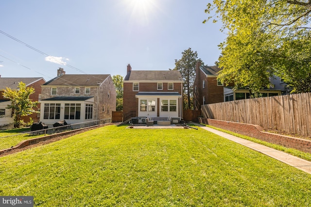 back of house featuring a sunroom, a lawn, and a patio area