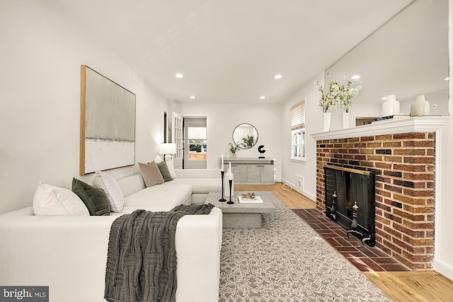 living room with hardwood / wood-style flooring and a brick fireplace