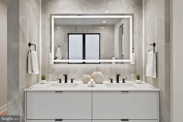 bathroom with vanity and tile walls