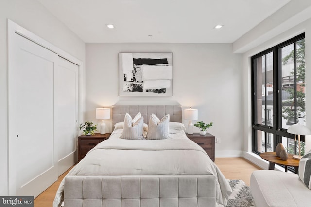 bedroom with light hardwood / wood-style flooring and a closet