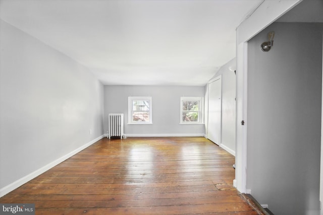 spare room with radiator heating unit and hardwood / wood-style floors