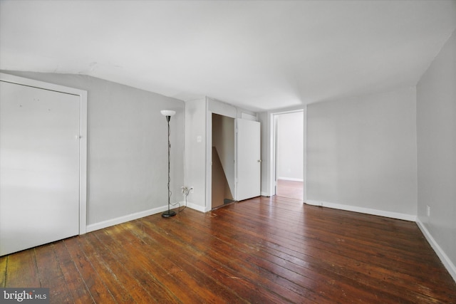 spare room with lofted ceiling and dark hardwood / wood-style flooring