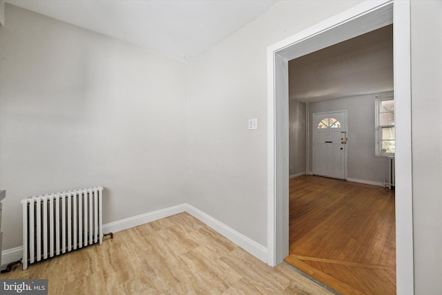 hallway featuring wood-type flooring and radiator heating unit