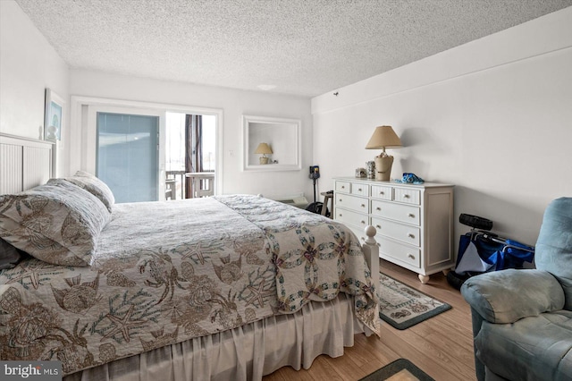 bedroom with a textured ceiling and hardwood / wood-style floors