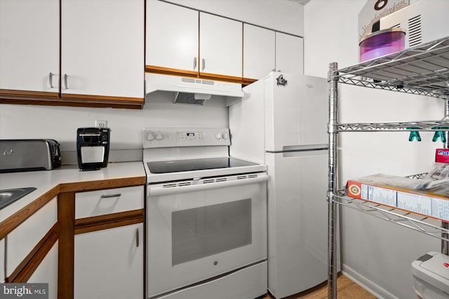 kitchen featuring white appliances, white cabinetry, and light hardwood / wood-style flooring