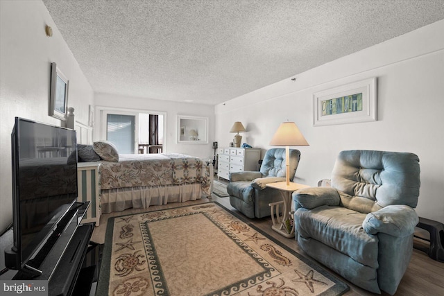 bedroom with a textured ceiling and wood-type flooring