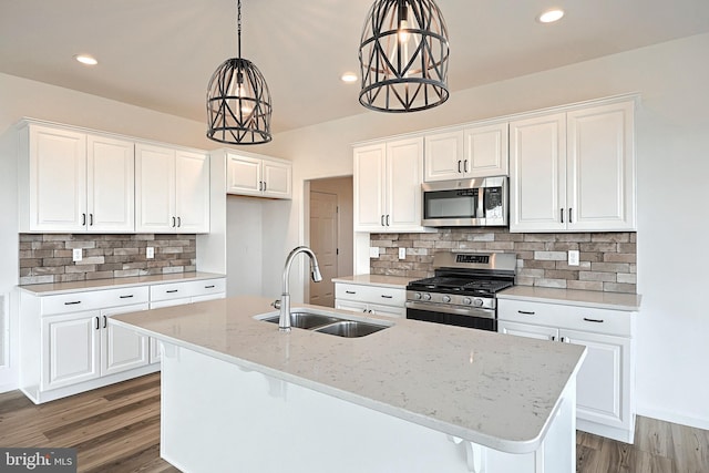 kitchen featuring white cabinetry, stainless steel appliances, sink, and light stone counters