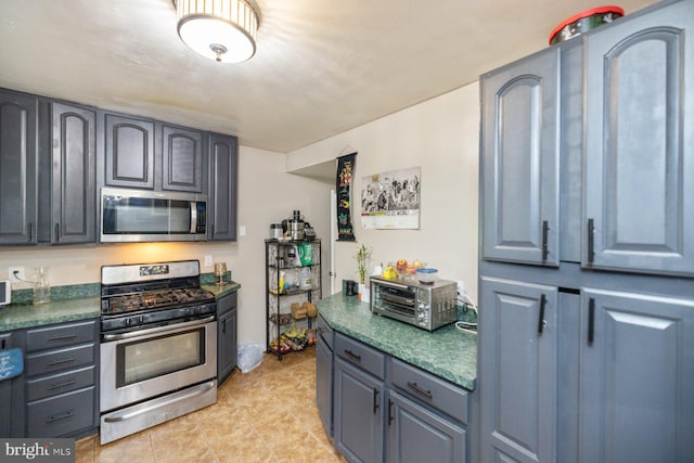 kitchen with appliances with stainless steel finishes and light tile patterned floors