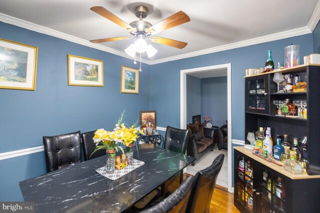 dining room featuring crown molding, light hardwood / wood-style flooring, and ceiling fan