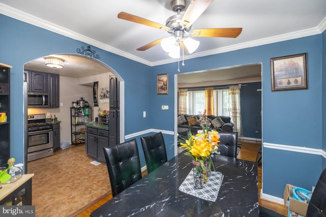 tiled dining area featuring ceiling fan and ornamental molding