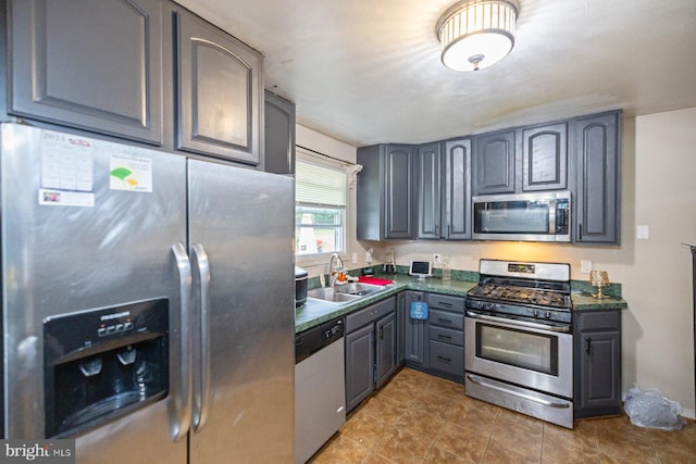 kitchen with gray cabinets, appliances with stainless steel finishes, and sink