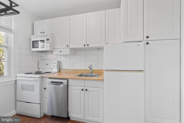 kitchen with dark wood-type flooring, backsplash, sink, white cabinets, and white appliances