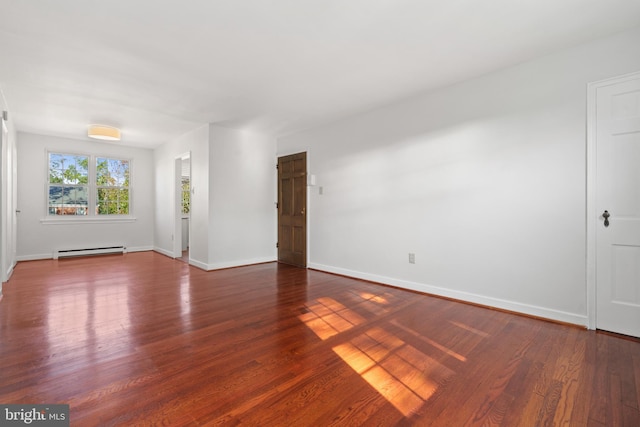 unfurnished room with a baseboard heating unit and dark hardwood / wood-style floors