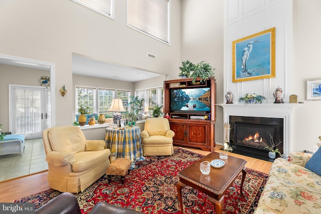 living room with a towering ceiling and wood-type flooring