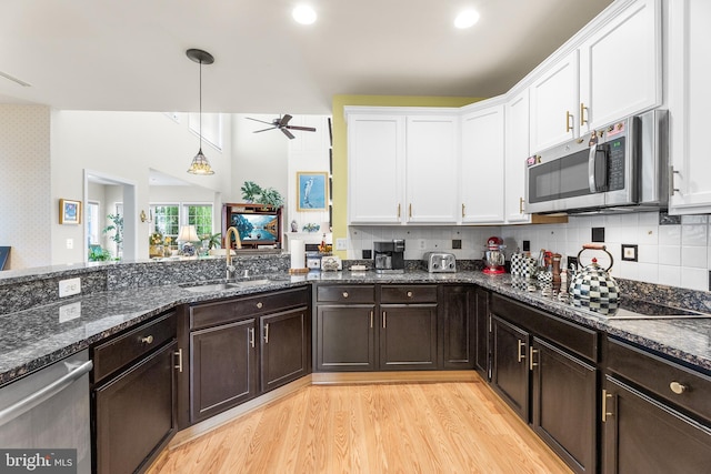 kitchen featuring ceiling fan, stainless steel appliances, sink, white cabinetry, and decorative light fixtures