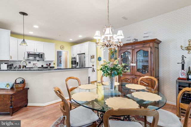 dining area featuring a notable chandelier and light hardwood / wood-style flooring