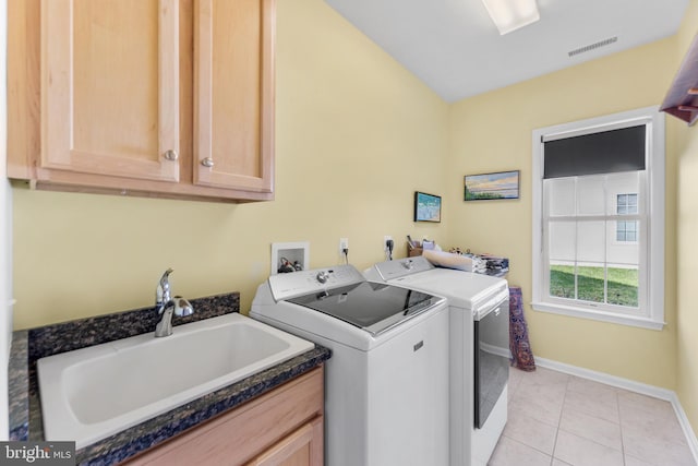 laundry area featuring independent washer and dryer, cabinets, sink, and light tile patterned floors