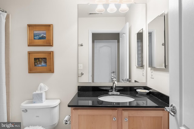 bathroom with vanity, toilet, and curtained shower