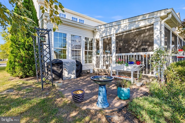 rear view of property featuring a patio and a sunroom