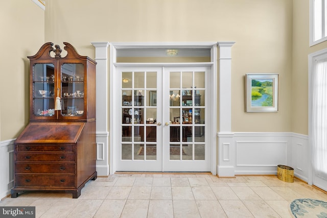 doorway with a high ceiling, french doors, and light tile patterned flooring