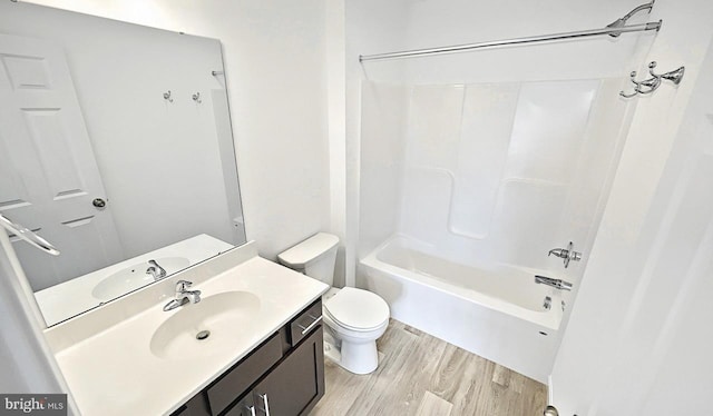 full bathroom with tub / shower combination, vanity, toilet, and wood-type flooring