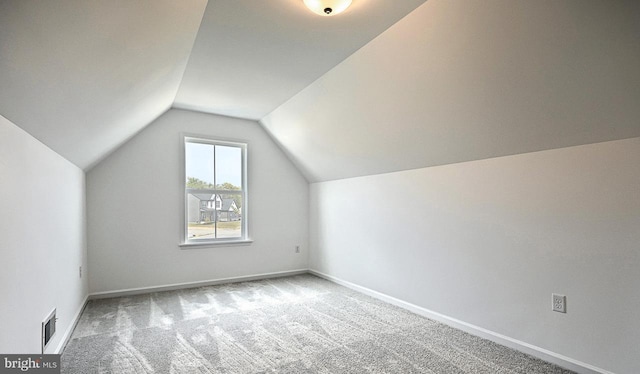 bonus room featuring lofted ceiling and light colored carpet