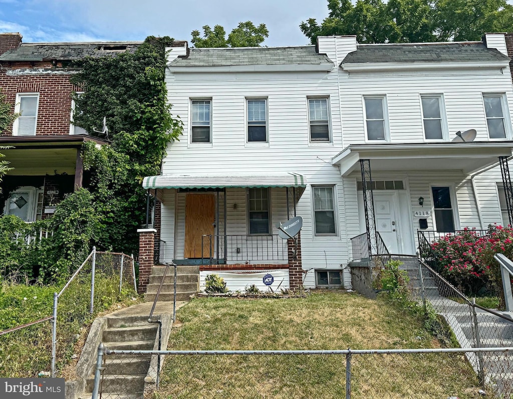 townhome / multi-family property featuring a front lawn and covered porch