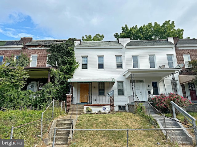 view of property with covered porch and a front yard