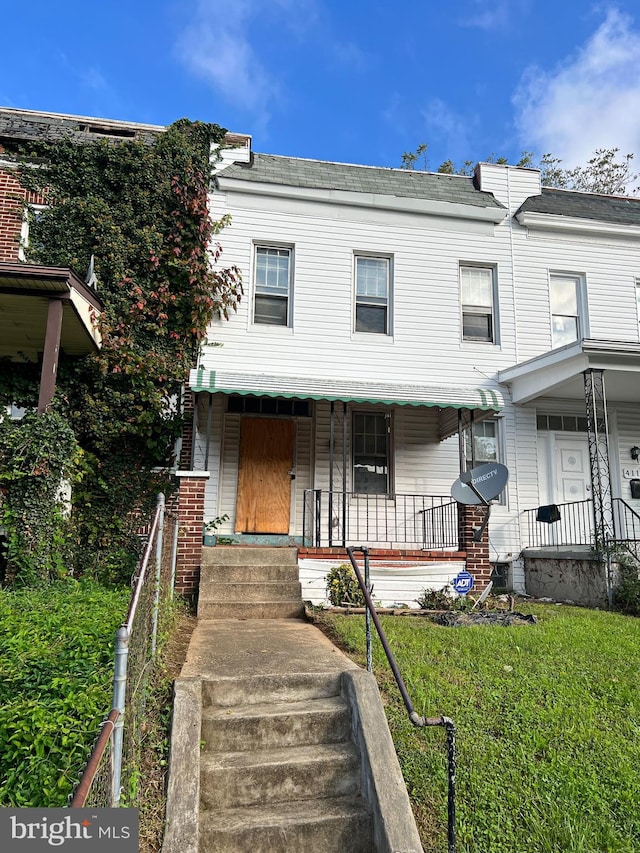 view of property featuring a porch and a front yard