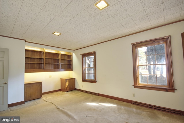 carpeted spare room featuring ornamental molding and a baseboard heating unit