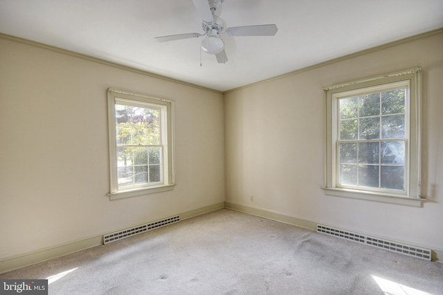 unfurnished room with light carpet, baseboard heating, ceiling fan, and a wealth of natural light