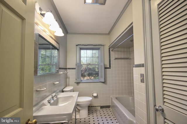 full bathroom with toilet, tile patterned flooring, ornamental molding, tile walls, and vanity