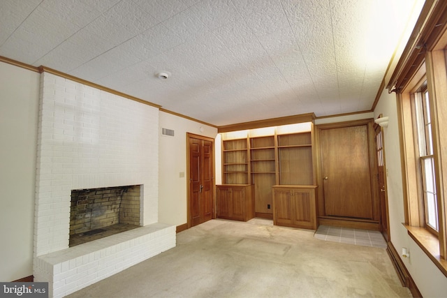 unfurnished living room featuring a fireplace, a textured ceiling, ornamental molding, and light colored carpet