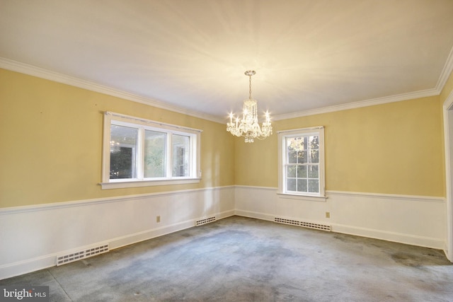 spare room with ornamental molding, carpet floors, and an inviting chandelier