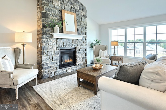 living room featuring vaulted ceiling, a fireplace, and dark hardwood / wood-style flooring