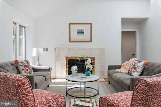 living room featuring lofted ceiling and a fireplace