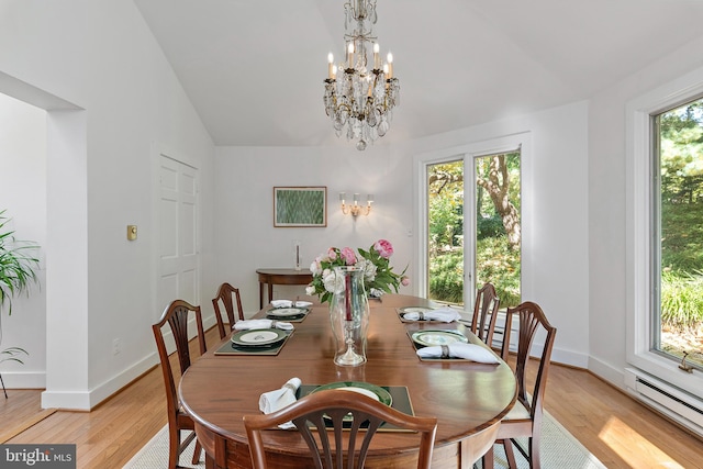 dining area featuring lofted ceiling, light wood-type flooring, and a wealth of natural light