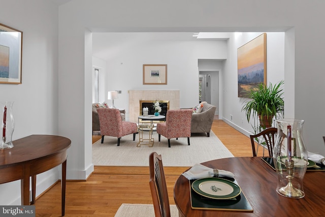 dining space with a fireplace and light wood-type flooring