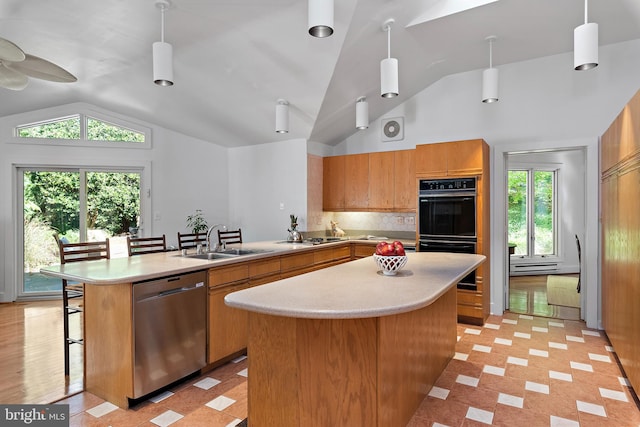 kitchen with stainless steel appliances, decorative light fixtures, and plenty of natural light