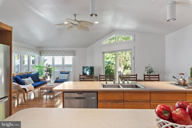 kitchen featuring lofted ceiling, light hardwood / wood-style flooring, sink, appliances with stainless steel finishes, and ceiling fan