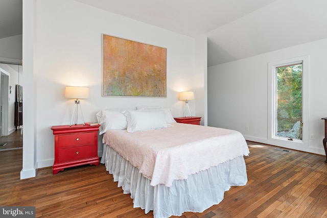 bedroom featuring dark wood-type flooring and vaulted ceiling