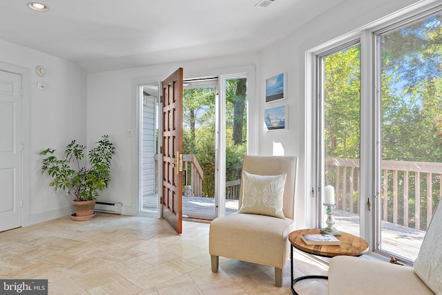 interior space featuring a baseboard heating unit and a healthy amount of sunlight